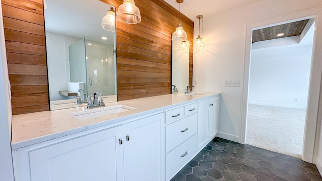 bathroom with tile patterned flooring, wooden walls, a sink, double vanity, and a stall shower