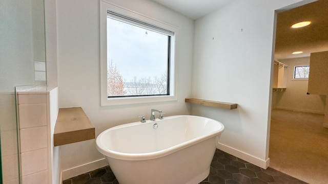 full bathroom featuring baseboards, a soaking tub, tile patterned flooring, and recessed lighting