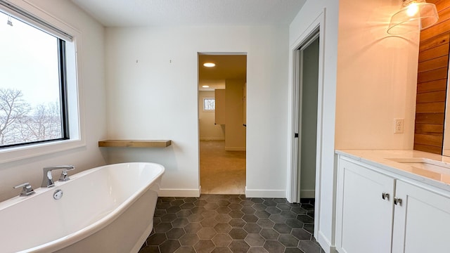 full bathroom with baseboards, tile patterned floors, a freestanding bath, vanity, and recessed lighting