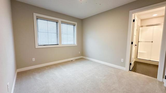 carpeted spare room with visible vents and baseboards