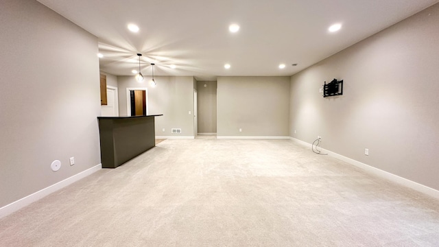 unfurnished living room featuring recessed lighting, light carpet, visible vents, and baseboards