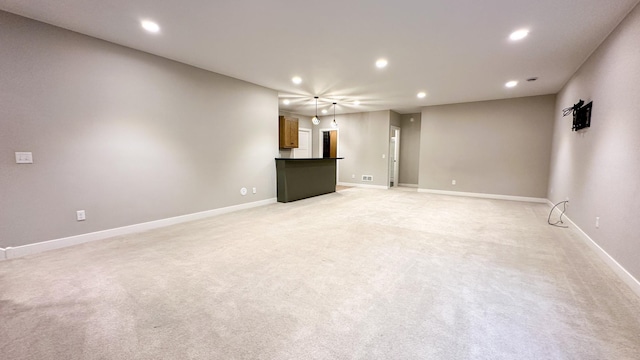 unfurnished living room with light carpet, baseboards, and recessed lighting