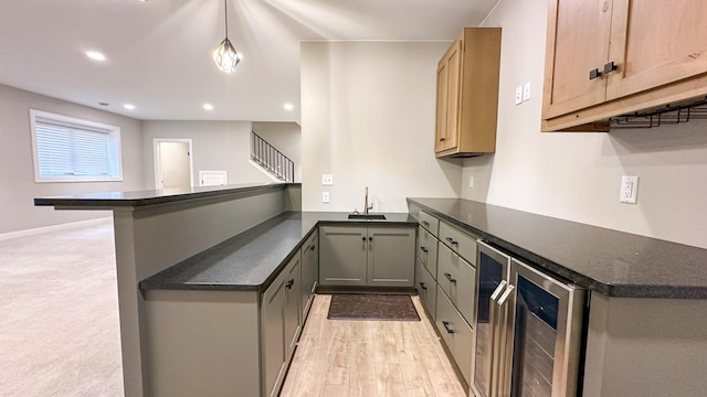 kitchen with wine cooler, recessed lighting, light wood-style flooring, a sink, and a peninsula