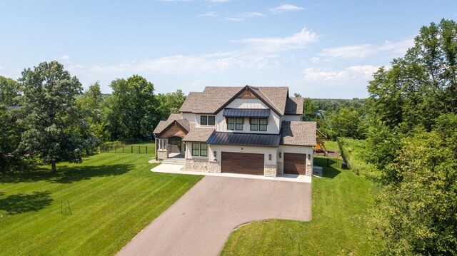 view of front facade with dirt driveway, an attached garage, a standing seam roof, metal roof, and a front lawn