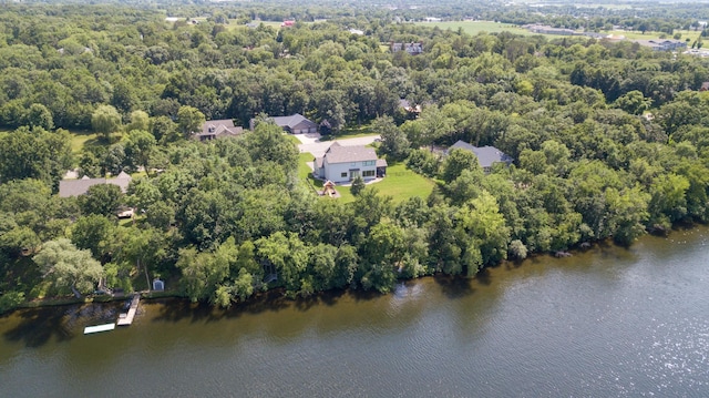 birds eye view of property featuring a water view and a wooded view