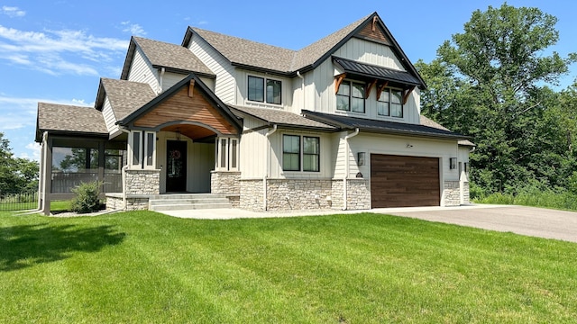 view of front of property featuring a garage, a shingled roof, concrete driveway, stone siding, and a front yard