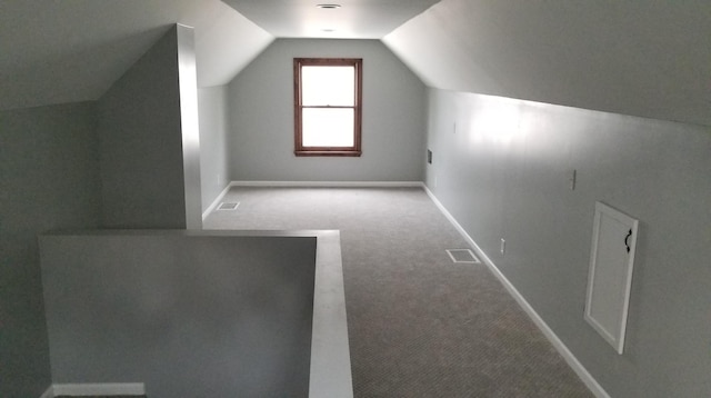 additional living space featuring vaulted ceiling, carpet floors, visible vents, and baseboards