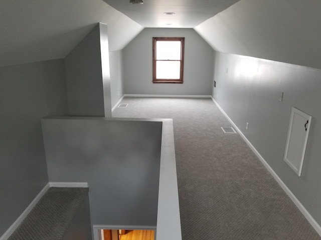 additional living space featuring lofted ceiling, carpet, visible vents, and baseboards