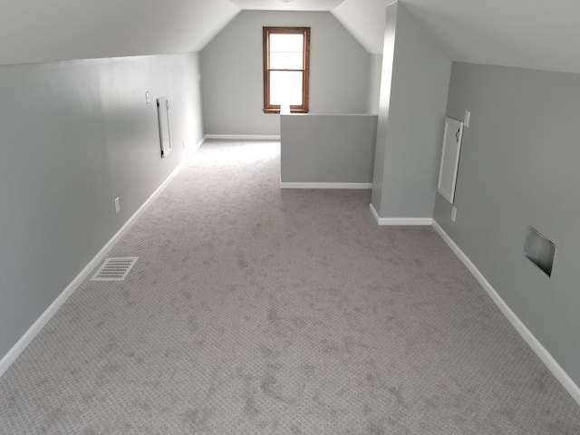 additional living space with lofted ceiling, baseboards, visible vents, and carpet flooring