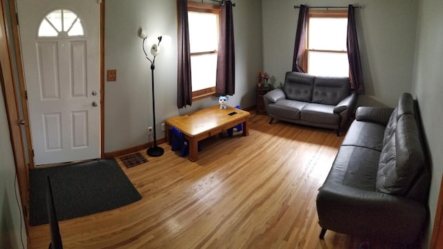 living room featuring baseboards, visible vents, and light wood-style floors