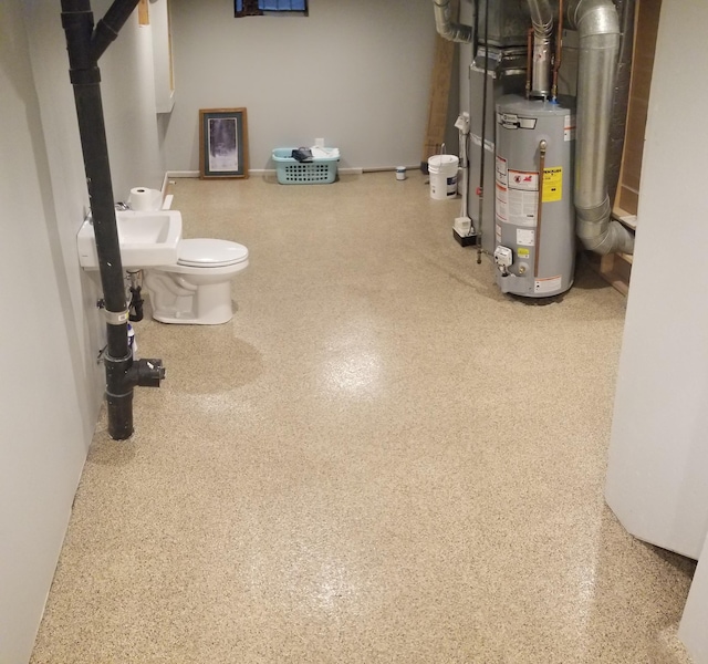 interior space featuring water heater, speckled floor, and a sink