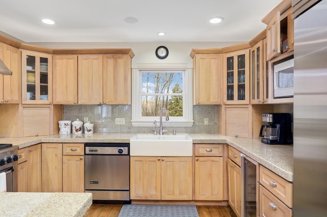 kitchen featuring wine cooler, light brown cabinets, a sink, appliances with stainless steel finishes, and tasteful backsplash