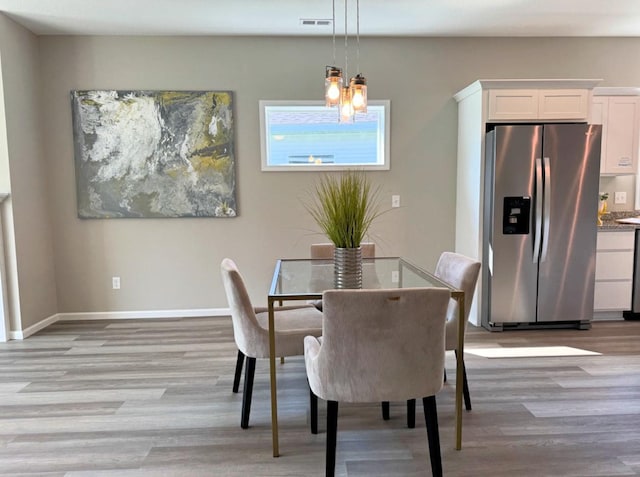 dining room featuring visible vents, a chandelier, light wood-style flooring, and baseboards