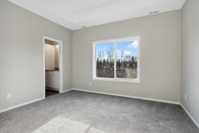 unfurnished bedroom with ensuite bathroom, carpet, visible vents, and baseboards