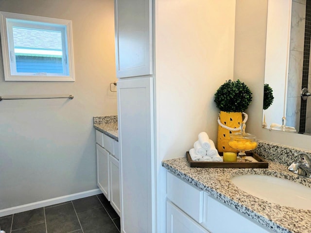 bathroom with vanity, baseboards, and tile patterned floors