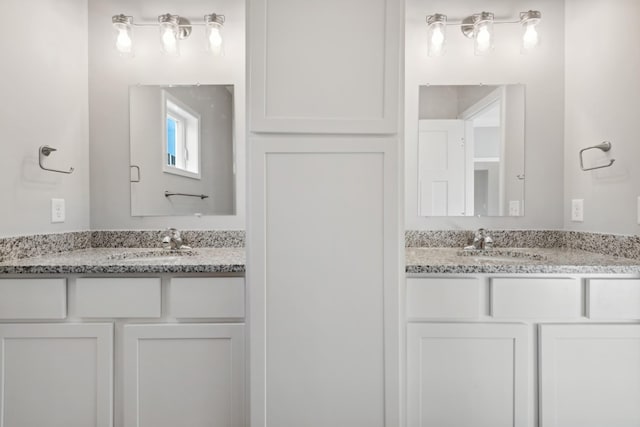 bathroom featuring two vanities and a sink