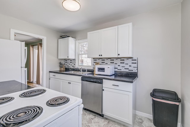 kitchen with white appliances, dark countertops, a sink, white cabinetry, and backsplash