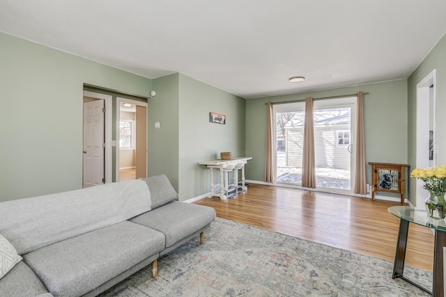 living area with baseboards and wood finished floors