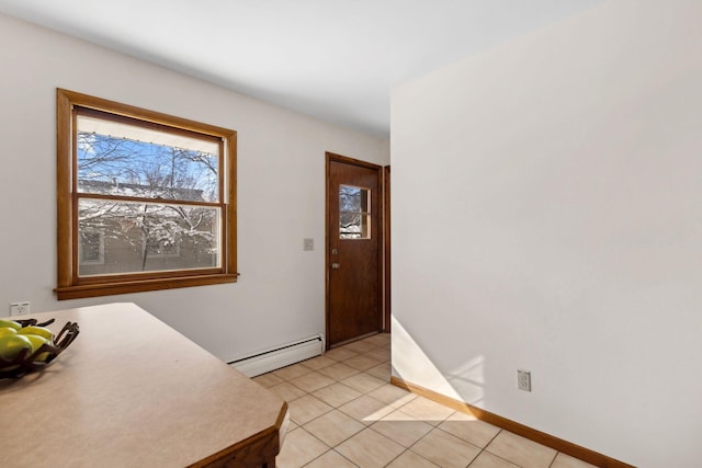 foyer with baseboard heating, light tile patterned flooring, and baseboards