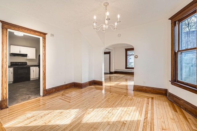 spare room with arched walkways, a baseboard radiator, a notable chandelier, baseboards, and light wood finished floors