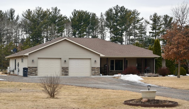 ranch-style house featuring an attached garage, covered porch, a shingled roof, stone siding, and driveway