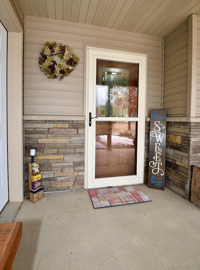 property entrance featuring stone siding