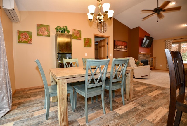 dining room featuring lofted ceiling, a fireplace, wood finished floors, and a wall mounted AC