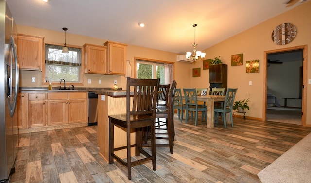 kitchen featuring stainless steel appliances, lofted ceiling, light brown cabinetry, wood finished floors, and a wall mounted air conditioner