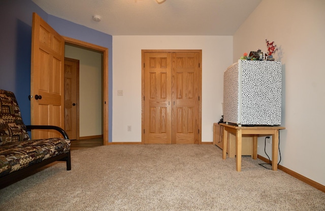 living area featuring carpet and baseboards