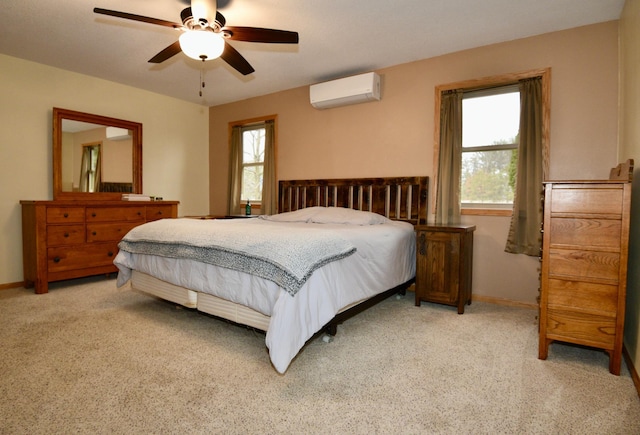 bedroom with light carpet, ceiling fan, a wall unit AC, and baseboards