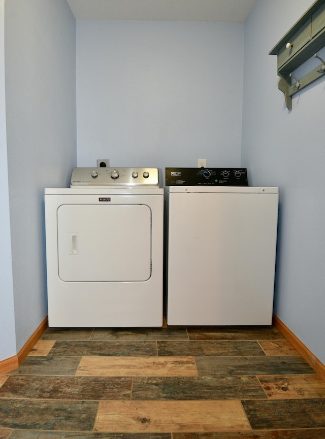 laundry room with laundry area, washing machine and dryer, baseboards, and dark wood finished floors