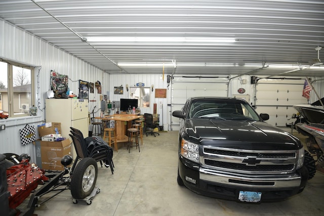 garage featuring freestanding refrigerator and metal wall