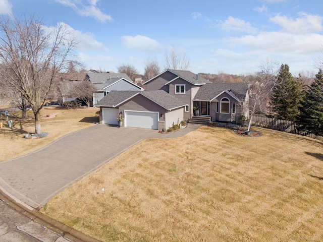 view of front facade with driveway, a shingled roof, an attached garage, fence, and a front yard