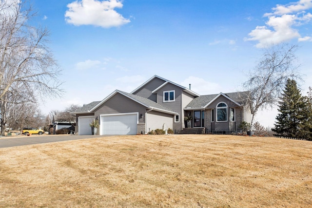 view of front of house with driveway, a front lawn, roof with shingles, and an attached garage