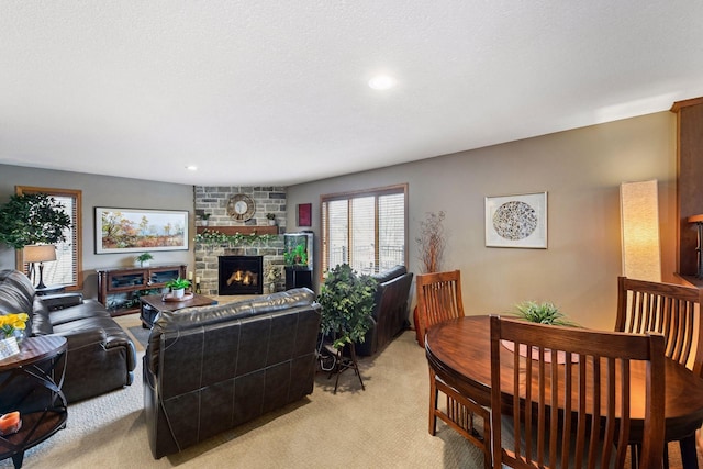 living room featuring light carpet, a textured ceiling, a fireplace, and recessed lighting