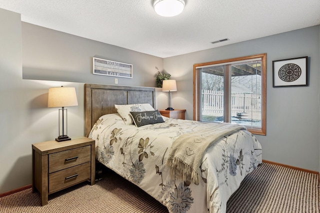 bedroom with access to outside, visible vents, a textured ceiling, and baseboards