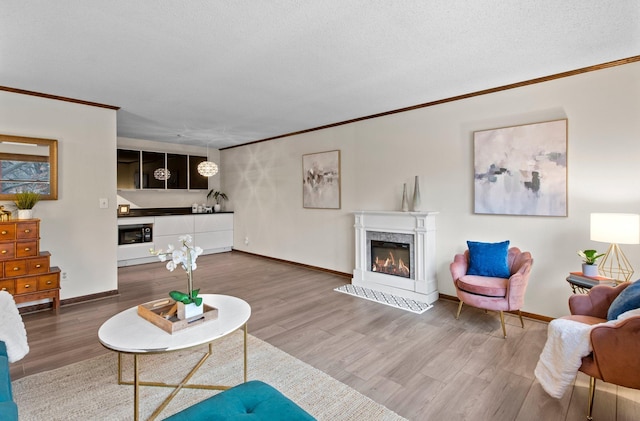 living area featuring a high end fireplace, ornamental molding, wood finished floors, and baseboards