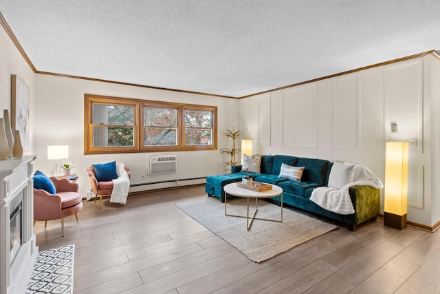 living room with crown molding, a textured ceiling, light wood-style floors, a baseboard heating unit, and a fireplace with flush hearth
