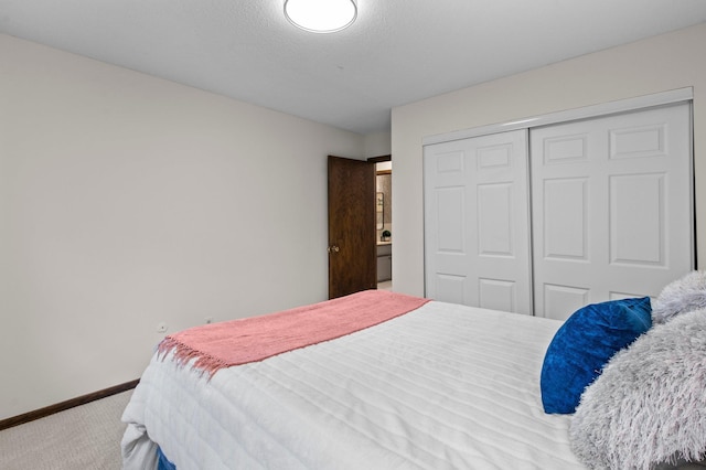 carpeted bedroom featuring baseboards and a closet