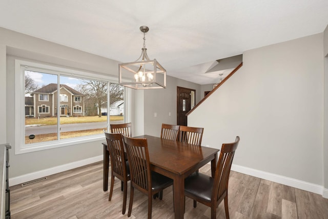 dining area with a notable chandelier, wood finished floors, visible vents, and baseboards