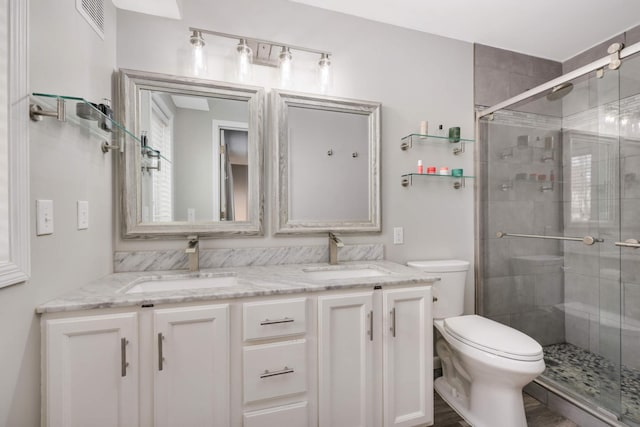 bathroom featuring a stall shower, a sink, and toilet