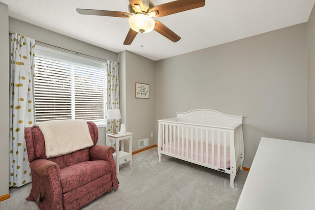 bedroom with a textured ceiling, carpet floors, a ceiling fan, visible vents, and baseboards