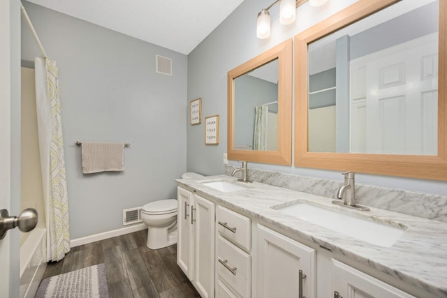 bathroom featuring toilet, a sink, and visible vents