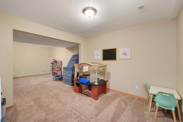 carpeted home office featuring a textured ceiling, visible vents, and baseboards