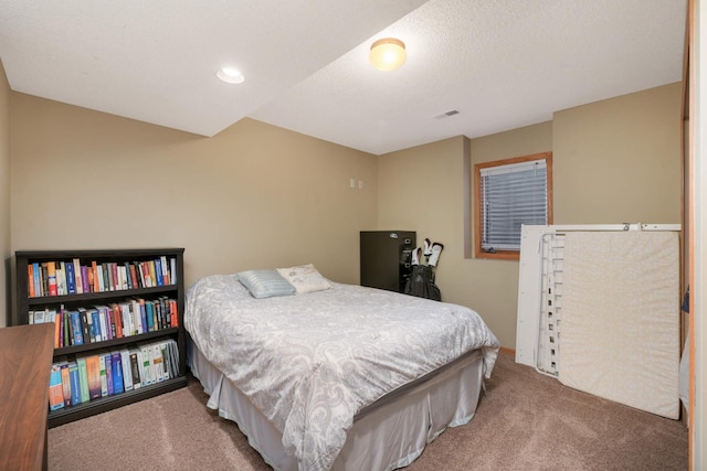 carpeted bedroom with visible vents and a textured ceiling