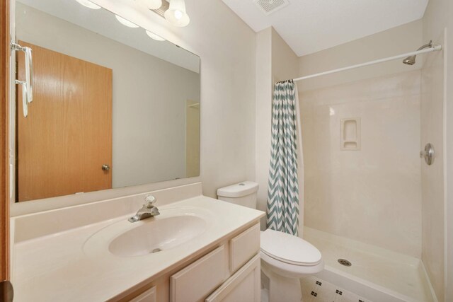 full bath with toilet, a stall shower, visible vents, and vanity