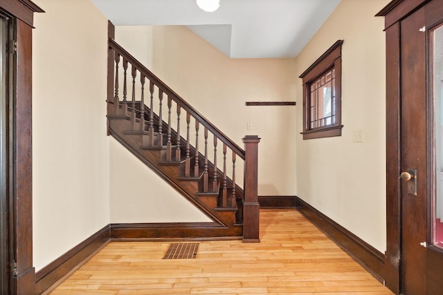 entryway featuring light wood-style flooring, stairway, visible vents, and baseboards