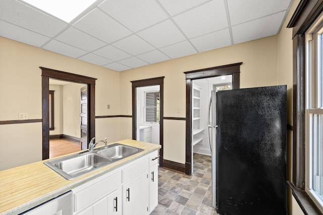 kitchen featuring a paneled ceiling, light countertops, appliances with stainless steel finishes, a sink, and independent washer and dryer