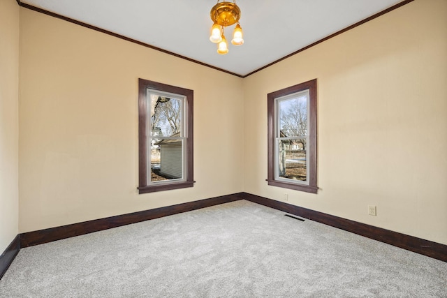 carpeted spare room featuring baseboards, visible vents, and ornamental molding