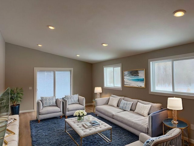 living area featuring recessed lighting, baseboards, lofted ceiling, and wood finished floors